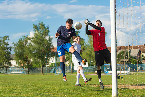 Goallie action Goallie defending action - boxing the ball away from the goal head shoot stock pictures, royalty-free photos & images