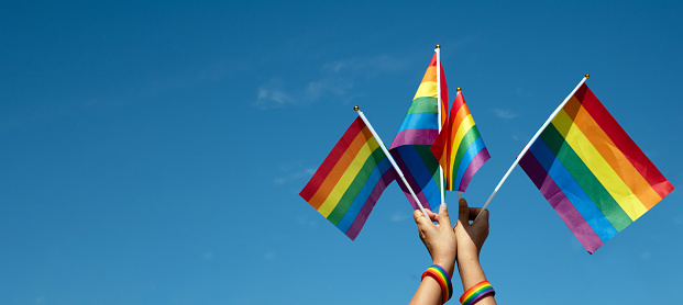 Rainbow flags, LGBT symbol, raising against bluesky, concept for celebrations and campaign of LGBTQ+ people and respect gender diversity in pride month around the world.