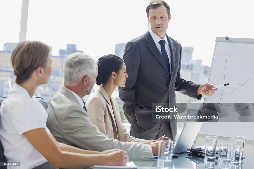 ビジネスマン、ホワイトボードに指を指すミーティング中 - よそいきの服のロイヤリティフリーストックフォト