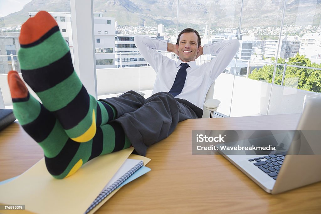 Souriant Homme d'affaires ayant une sieste avec les pieds sur le bureau - Photo de Activités de week-end libre de droits