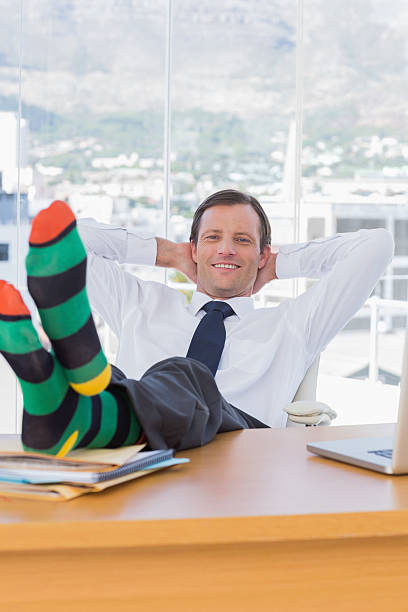 istock Cheerful businessman relaxing with feet on his desk 176593320