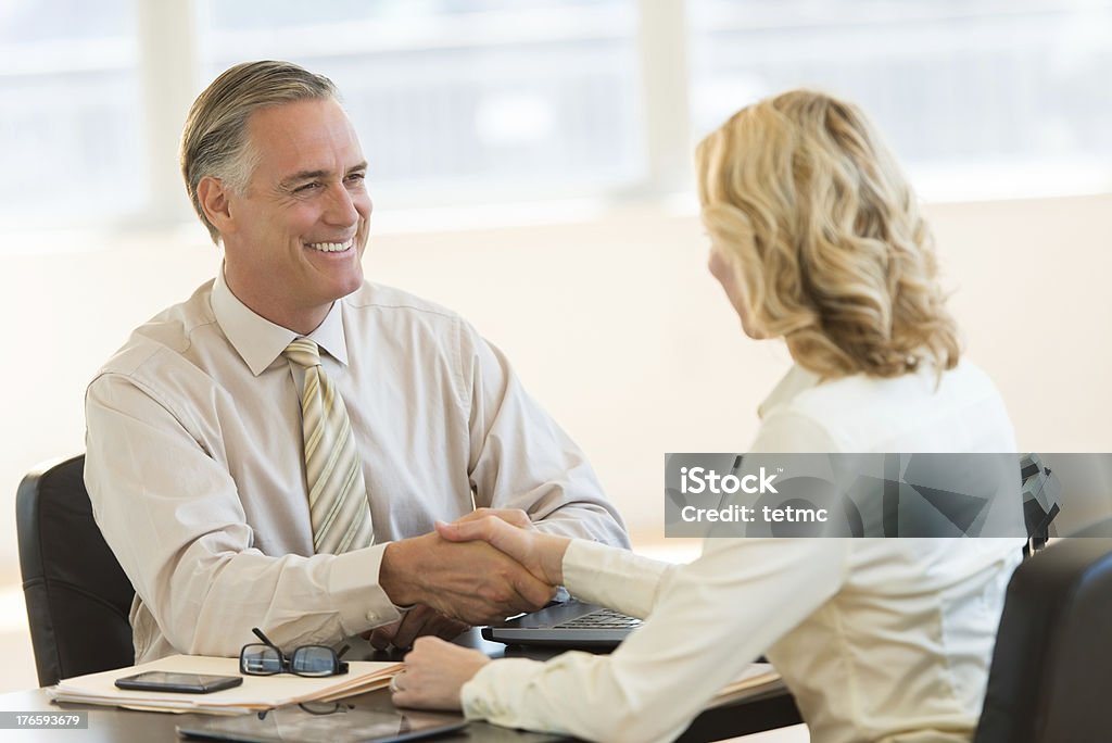 Biznesmen drżenie ręki z kolega na biurko - Zbiór zdjęć royalty-free (40-44 lata)