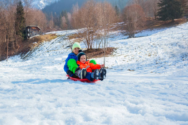 istock Two boys, brothers, slide downhill on the alpine slope together 1765967698