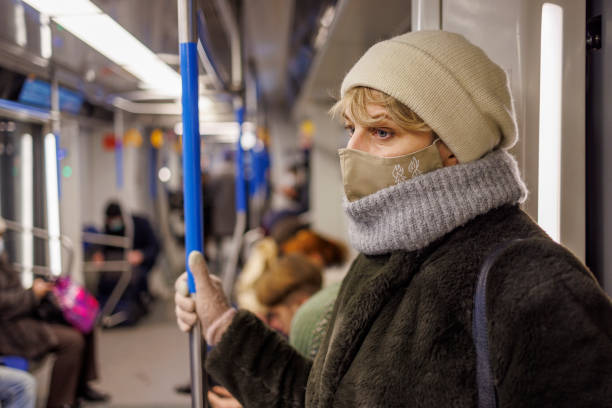 dojazd metrem w czasie pandemii. dojrzała kobieta nosząca maskę ochronną na twarz dla bezpieczeństwa publicznego jadąca pociągiem wypełnionym ludźmi. - unrecognizable person human face large group of people crowd zdjęcia i obrazy z banku zdjęć