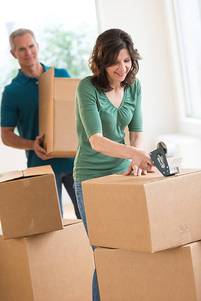 istock Woman Packing Cardboard Box At Home 176599051