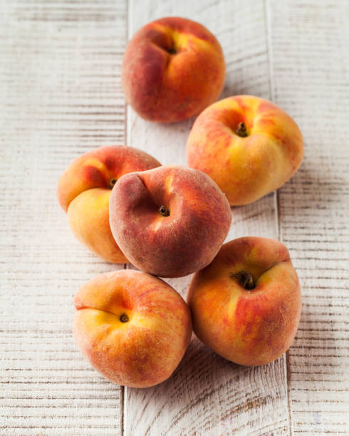 istock Ripe fruit peaches on a white wooden background. Fruit. 1766010212