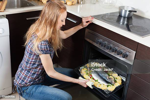 Rapariga Normal Cozinhar Peixe Cru No Forno - Fotografias de stock e mais imagens de Adulto - Adulto, Afazeres Domésticos, Arenque