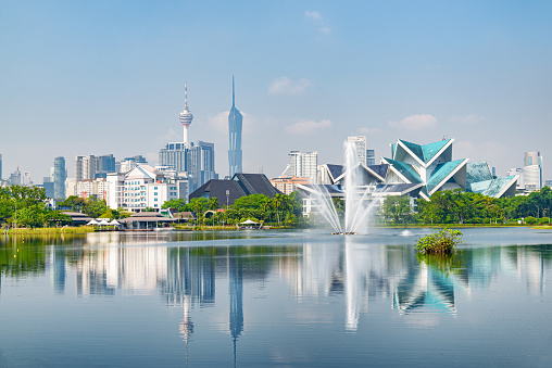 Awesome Kuala Lumpur skyline. Amazing view of scenic lake and fountains in a city park of Kuala Lumpur, Malaysia. Beautiful cityscape. Kuala Lumpur is a popular tourist destination of Asia.