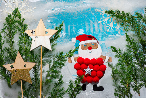 Winter, New Year or Christmas background with a smiling, happy Santa Claus. Santa is in a winter landscape, with snow, stars, sparkling ice and green needles. Winter concept, Christmas and New Year atmosphere