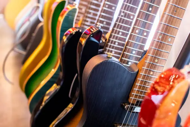 Photo of Selective focus to electric guitar in music shop, many electric guitars, pop rock artist song music and entertainment instrument.