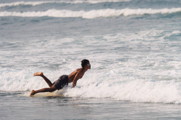 istock Indonesian Surfer Jumping Over a Wave on a Longboard 1766067224