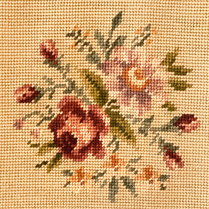 Antique floral needlepoint with roses in gold tones.