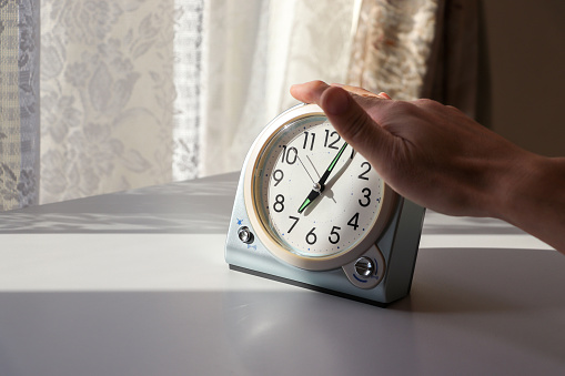 Press the button on the alarm clock to stop the alarm