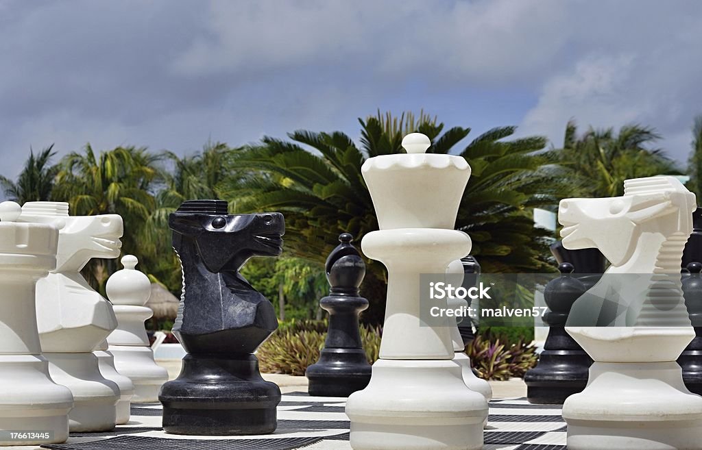 Big chess for game on a beach Big black and white figures for game in chess on a beach during rest Chess Stock Photo