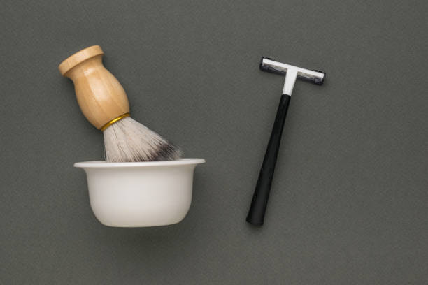 istock A brush with a cup and a man's razor on a gray background. 1766135385