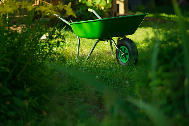 An old wooden wheelbarrow overflows with spring artificial flowers outside a flower shop on Cape Cod.