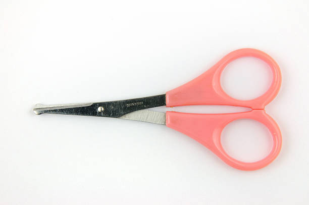 Pink stainless scissors for kid's nail cutting isolated on white background.