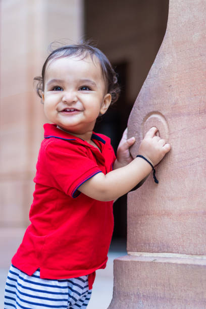 istock toddler baby boy cute facial expression standing with wall support in casual appearance at outdoor 1766179607
