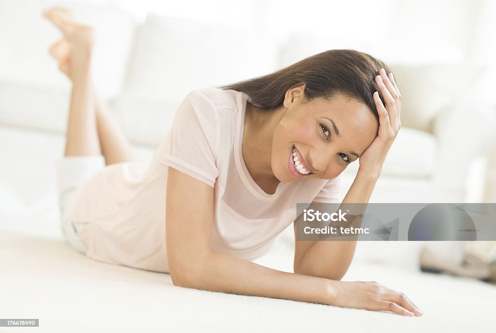 Glückliche Frau, die auf dem Boden liegen, wie zu Hause fühlen. - Lizenzfrei 25-29 Jahre Stock-Foto