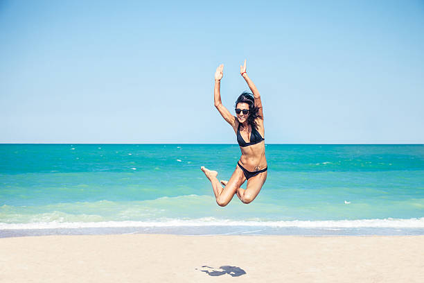 istock Happy woman jumping on the beach 176618615