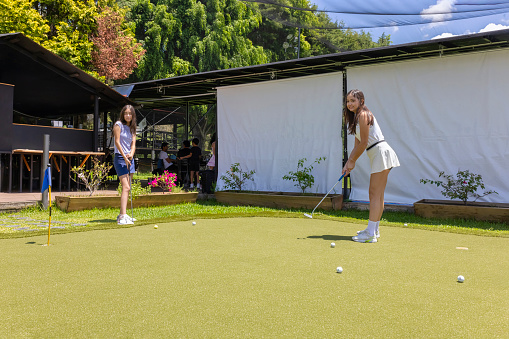 Youngsters practising mini golf