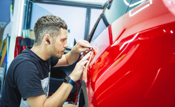 istock The process of installing protective film on the new red car. 1766228211