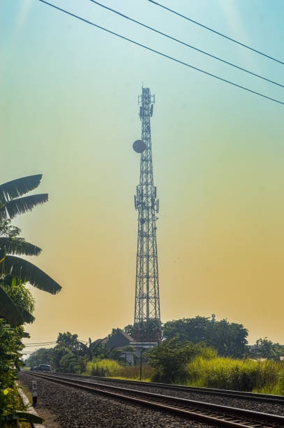 istock a cellular communications transmitter tower towering next to a double-track railroad track 1766240260