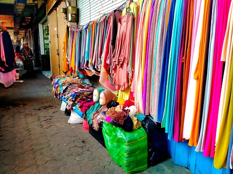 Malang, Indonesia - September 3, 2023 ; Hijab fabric sellers display their wares along the sidewalks in front of stalls at 