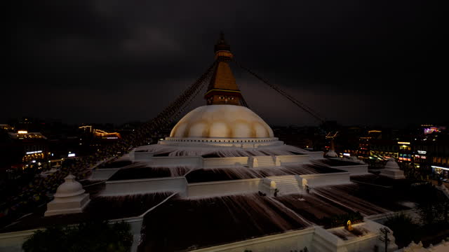 Ending day 4K sunset time lapse of Boudha Stupa (Boudhanath) in Kathmandu, Nepal. Buddhist flags waving on the wind. Beautiful architekture and Buddhism religion concept video.