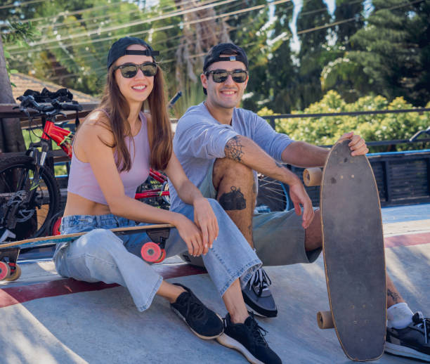 junges glückliches paar mit skateboards genießt longboarden im skatepark - 18803 stock-fotos und bilder