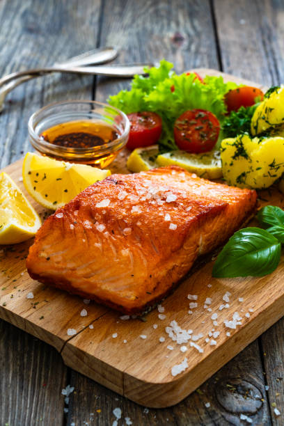 istock Seared salmon with boiled potatoes and fresh vegetables on wooden table 1766265061