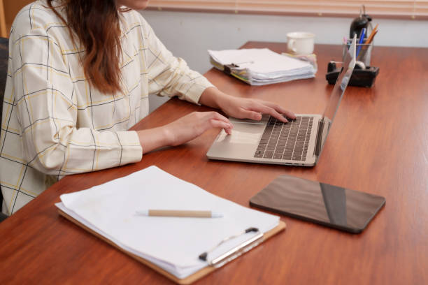 istock Young Asian woman hands working, office workers, sit and working in home offices, While period working from home, there is no need go office, working in front laptop computer at home is boring. 1766269178
