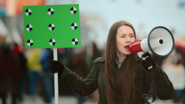jovem mulher com megafone na manifestação - protestor protest sign strike - fotografias e filmes do acervo