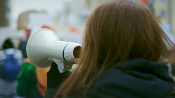 Young woman with megaphone at demonstration