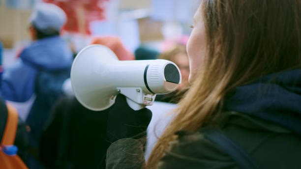 istock Young woman with megaphone at demonstration 1766289556