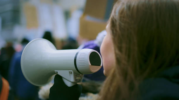 istock Young woman with megaphone at demonstration 1766291158