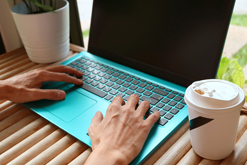 People working with a cup of coffee beside his laptop