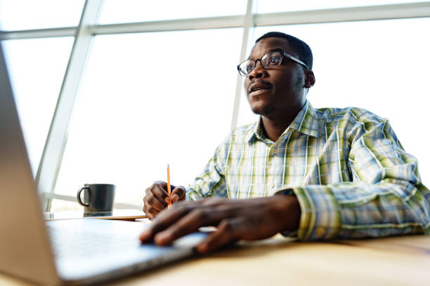 istock Serious concentrated african man studying or working with laptop indoors 1766315633