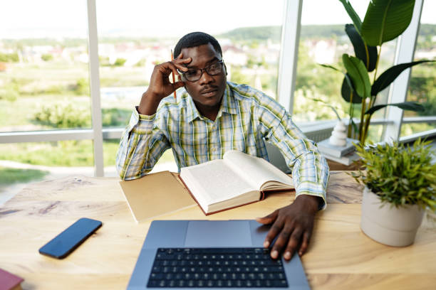 istock Serious concentrated african man studying or working with laptop indoors 1766336646