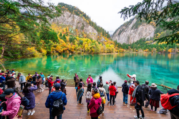 Crowd of tourists looking at beautiful autumn scenery at jiuzhaigou national park in Chengdu, China stock photo