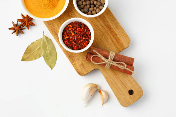 istock Bowls with spices on wooden board on white background 1766340898