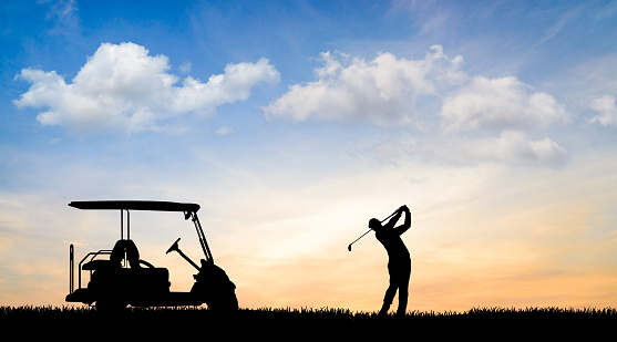Golfer swinging at beautiful sunset
