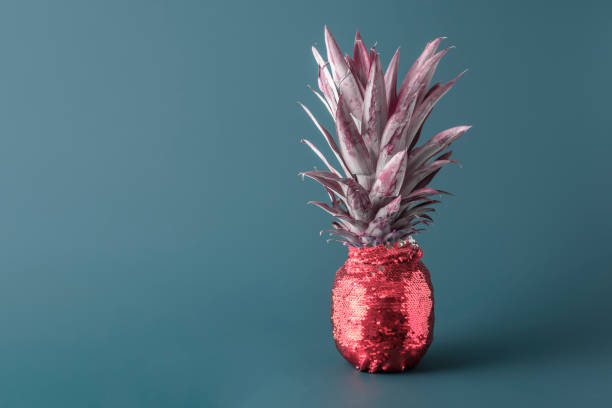 istock Creative fruit concept. Pineapple in red glittery evening attire on blue background with copy space. 1766372179