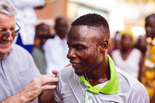 abidjan, Ivory Coast – February 26, 2023: A joyful man participating in an Abidjan, Cote d'Ivoire baptism ceremony, rejoicing in his faith