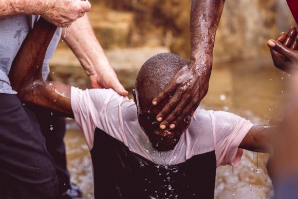 radosny mężczyzna uczestniczący w ceremonii chrztu w abidżanie na wybrzeżu kości słoniowej, radujący się swoją wiarą - chrzestny zdjęcia i obrazy z banku zdjęć