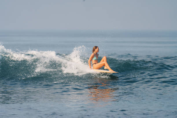 istock Athletic Blonde White Woman Sitting on Surfboard Riding Wave 1766413791