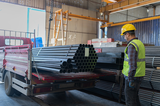 Metal Worker Loading Steel Metal Pipes Tubes With Crane In Factory Warehouse