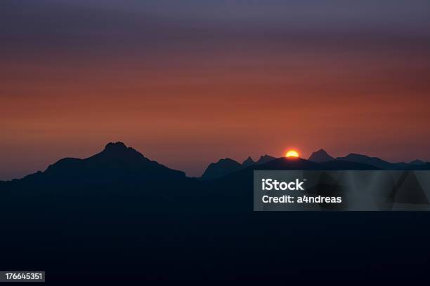 Dawn オレンジボールの太陽の下に表示される山のチェーン - オレンジ色のストックフォトや画像を多数ご用意 - オレンジ色, オーストリア, シルエット