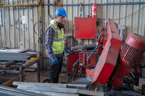 Metal Cutter Operator Cutting Steel Metal Tubes In An Industrial Factory