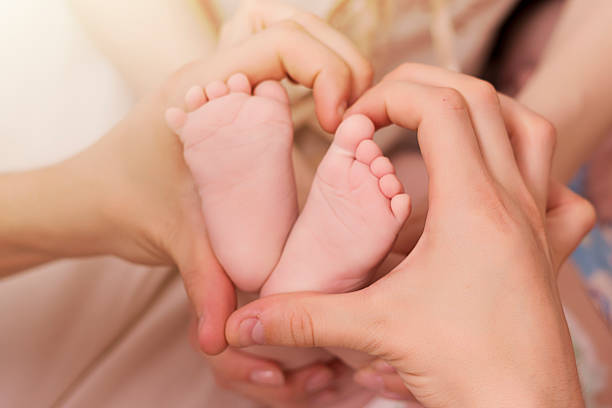 Zbliżenie baby's obcasy i ręce rodziców – zdjęcie